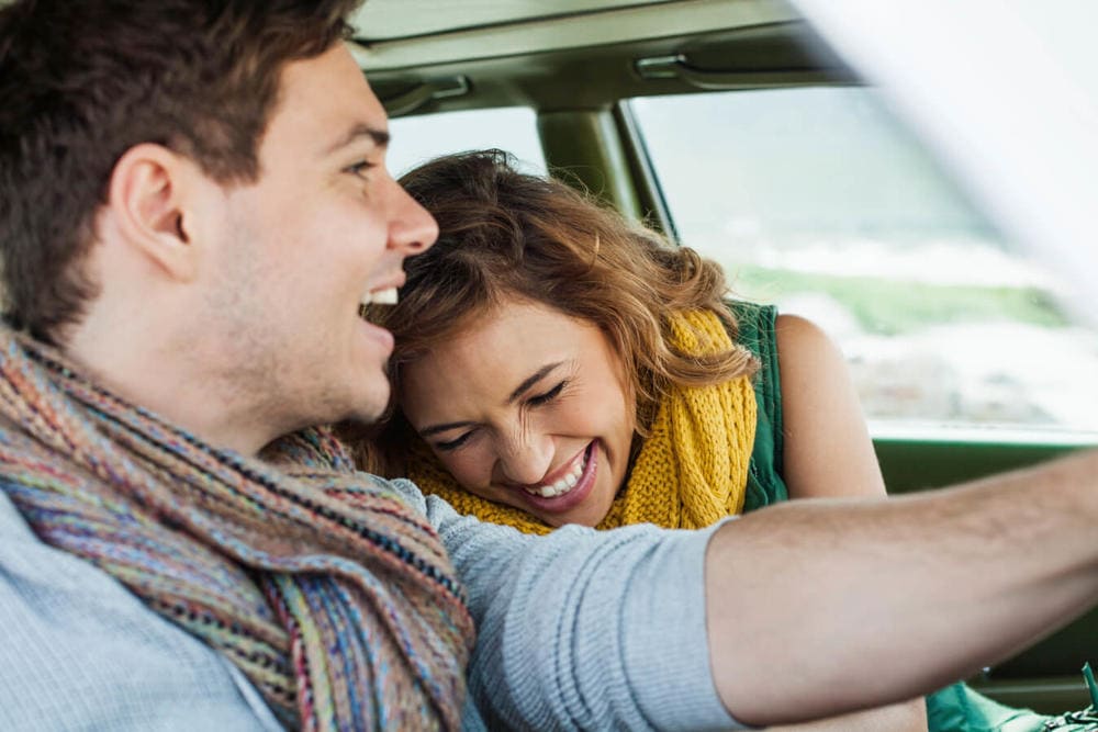 laughing couple in a car